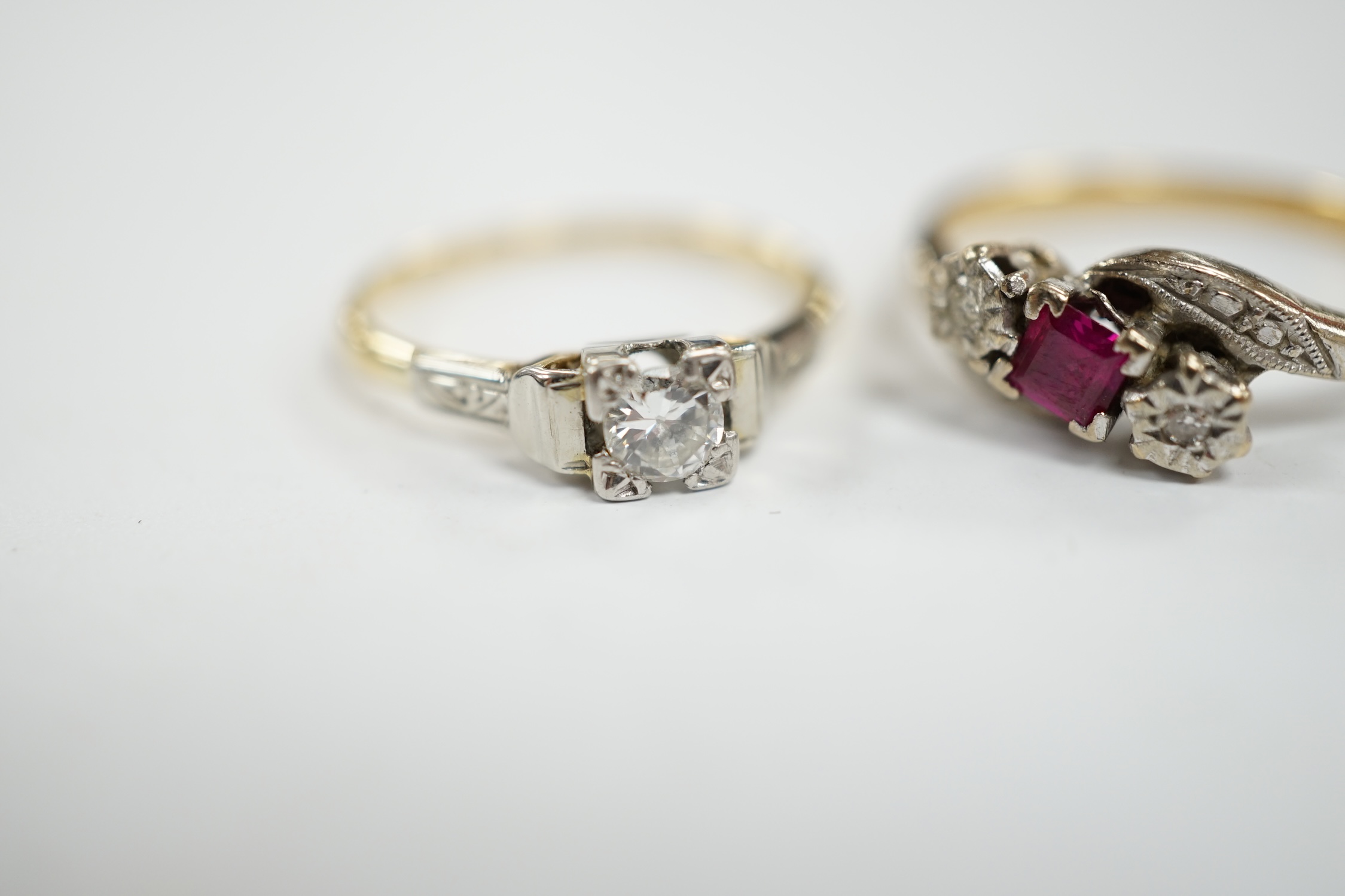 An 18ct, ruby and diamond chip set three stone crossover ring, size R and an 18ct, plat and solitaire diamond set ring, size N/O, gross weight 6.7 grams. Condition - fair